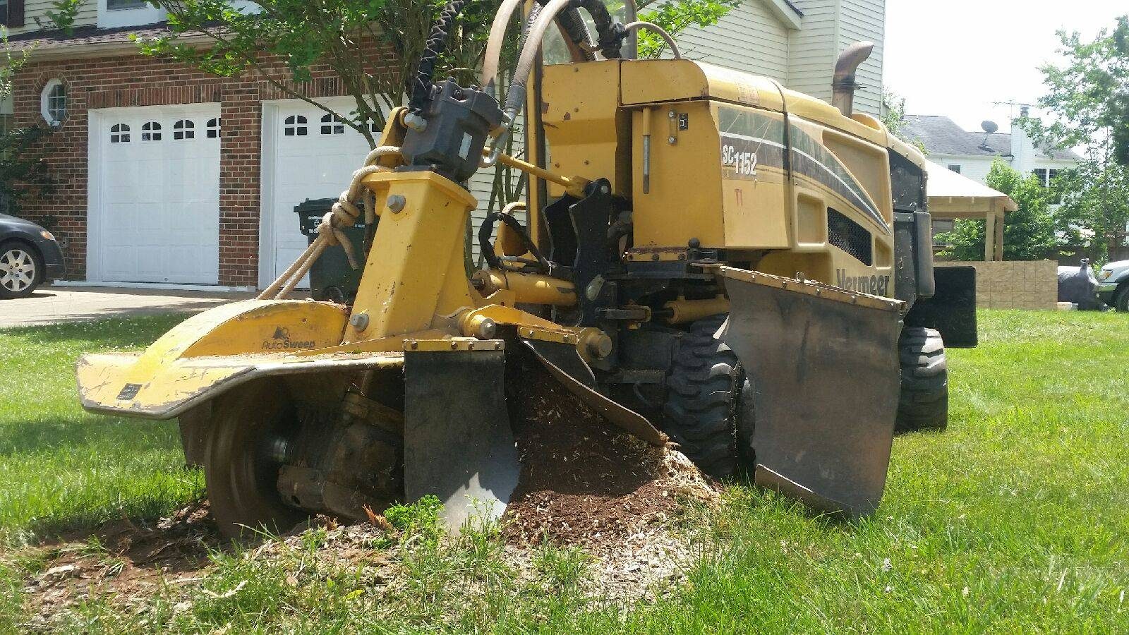 A stump grinder in use, grinding a stump flush to the ground